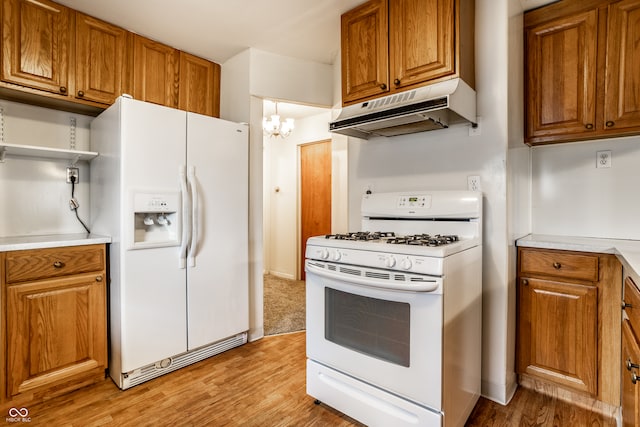 kitchen featuring light hardwood / wood-style flooring, hanging light fixtures, white appliances, and a notable chandelier