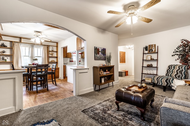 carpeted living room with ceiling fan