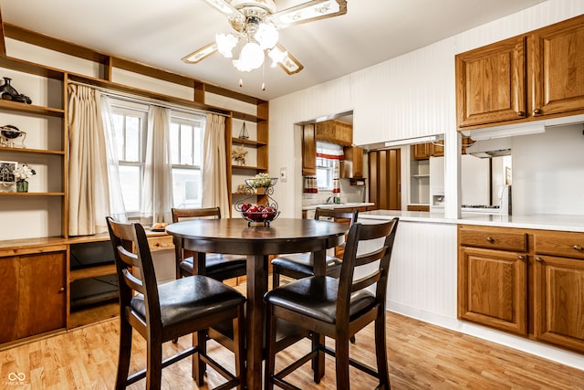 dining space with light hardwood / wood-style flooring and ceiling fan