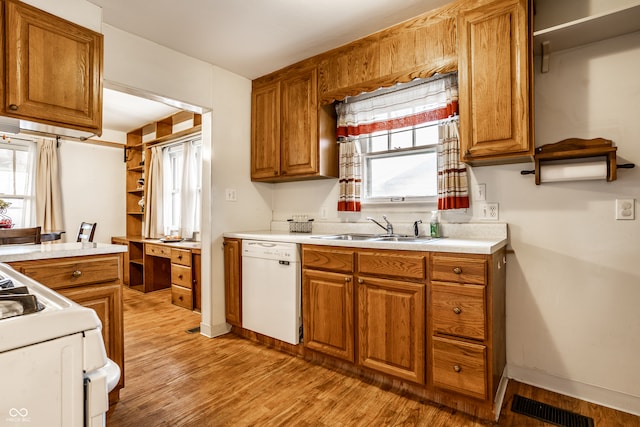 kitchen featuring a healthy amount of sunlight, light wood-type flooring, white appliances, and sink