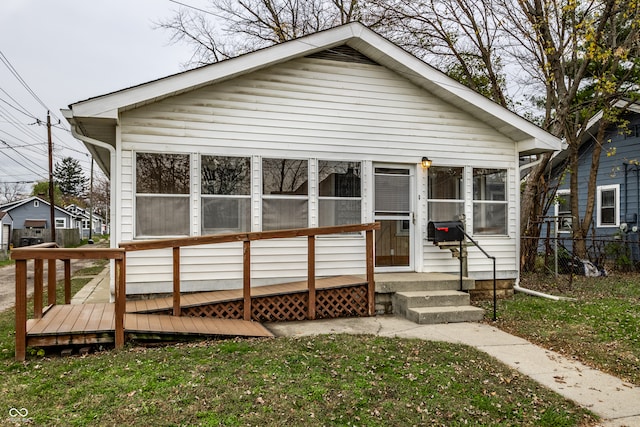 bungalow-style home featuring a sunroom and a front yard