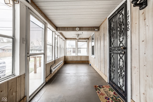 unfurnished sunroom with ceiling fan and a baseboard heating unit