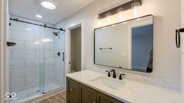 bathroom with hardwood / wood-style floors, vanity, toilet, and an enclosed shower