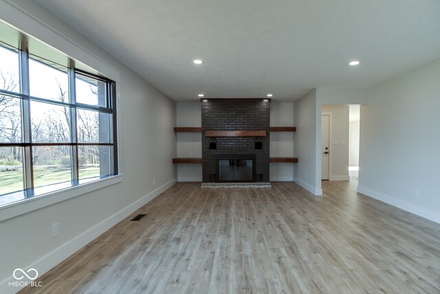 unfurnished living room featuring light hardwood / wood-style floors and a fireplace