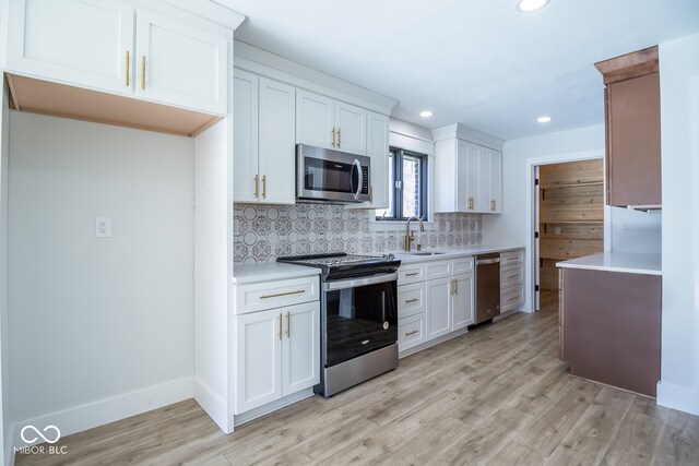 kitchen featuring backsplash, white cabinets, stainless steel appliances, and light wood-type flooring