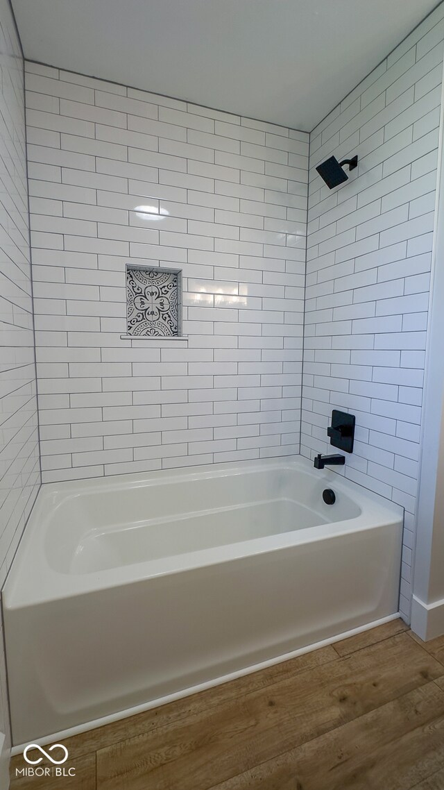 bathroom with wood-type flooring and tiled shower / bath combo