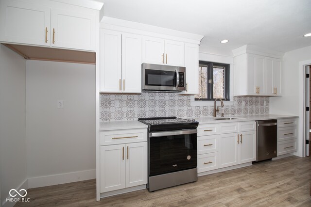 kitchen featuring white cabinets, stainless steel appliances, and light hardwood / wood-style floors