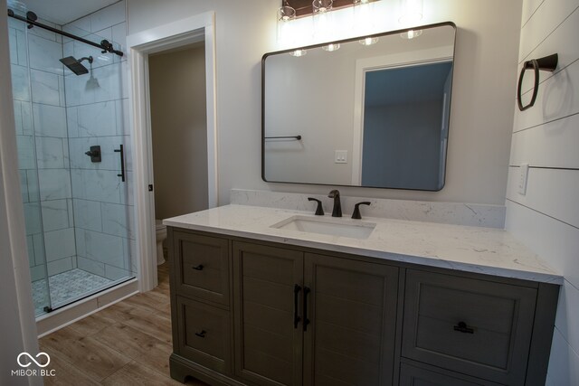 bathroom featuring hardwood / wood-style flooring, vanity, toilet, and walk in shower