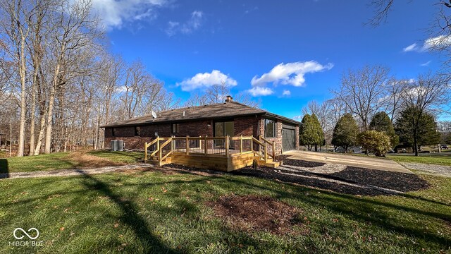 exterior space featuring cooling unit, a garage, and a yard