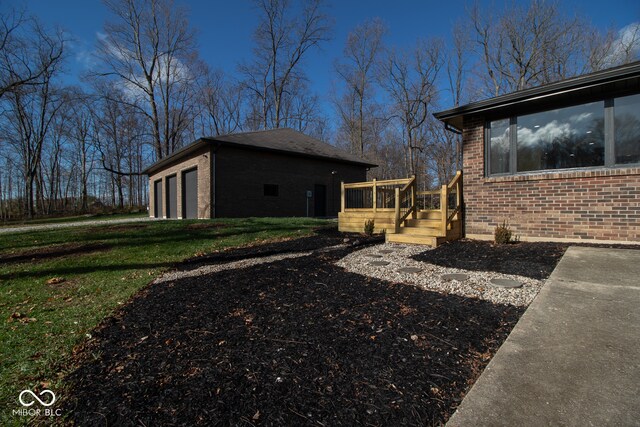 view of home's exterior with a lawn, a garage, and a deck