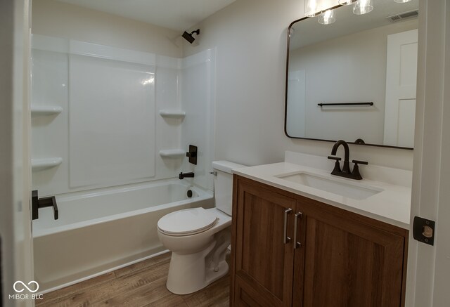 full bathroom with shower / tub combination, vanity, hardwood / wood-style flooring, and toilet