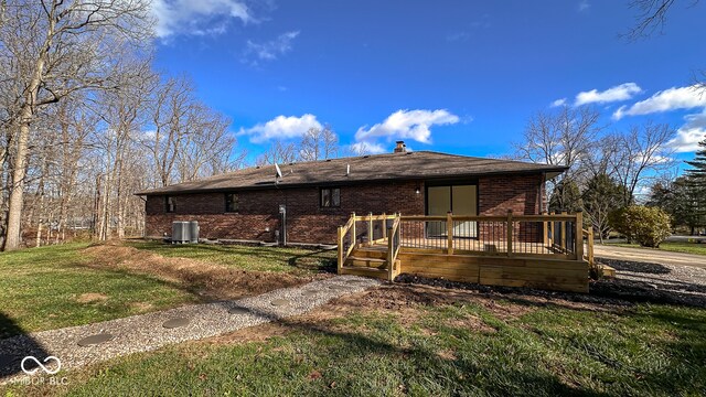 back of property with a yard, central air condition unit, and a wooden deck