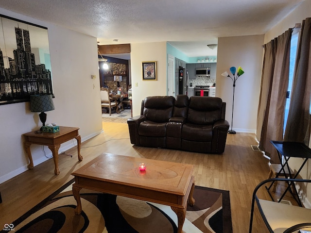 living room featuring light hardwood / wood-style flooring and a textured ceiling