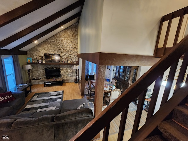 living room featuring hardwood / wood-style flooring, high vaulted ceiling, and beamed ceiling