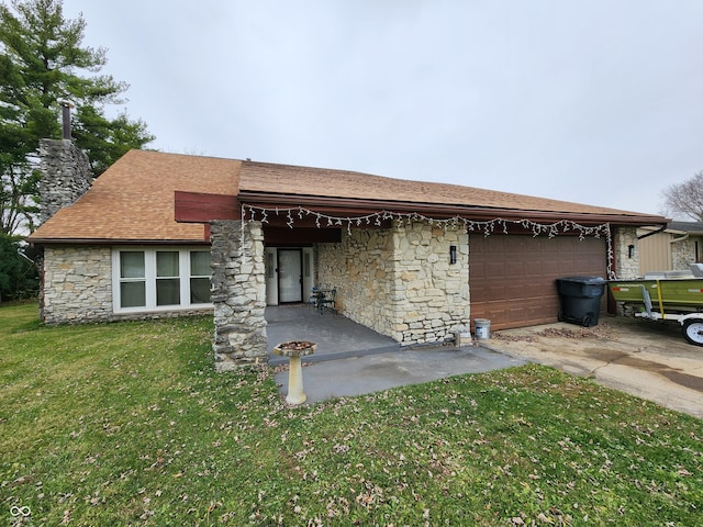 back of house with a garage and a yard