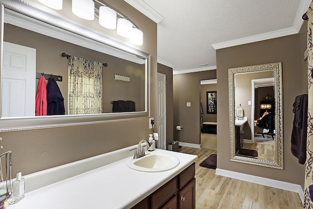 bathroom featuring hardwood / wood-style floors, vanity, a textured ceiling, and crown molding