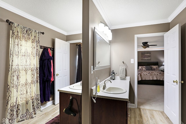 bathroom with vanity, crown molding, hardwood / wood-style flooring, ceiling fan, and a textured ceiling