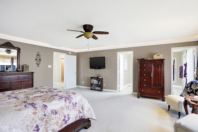 carpeted bedroom featuring ceiling fan, crown molding, and ensuite bath