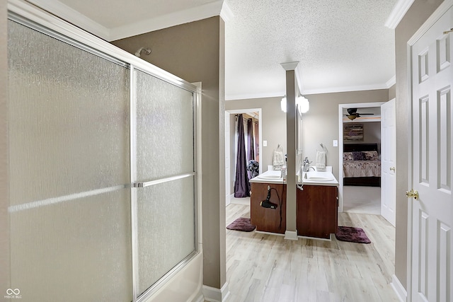 bathroom with vanity, hardwood / wood-style floors, a textured ceiling, and ornamental molding