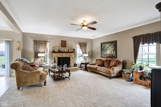 living room featuring a fireplace, plenty of natural light, crown molding, and ceiling fan