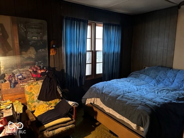 bedroom featuring carpet and wooden walls