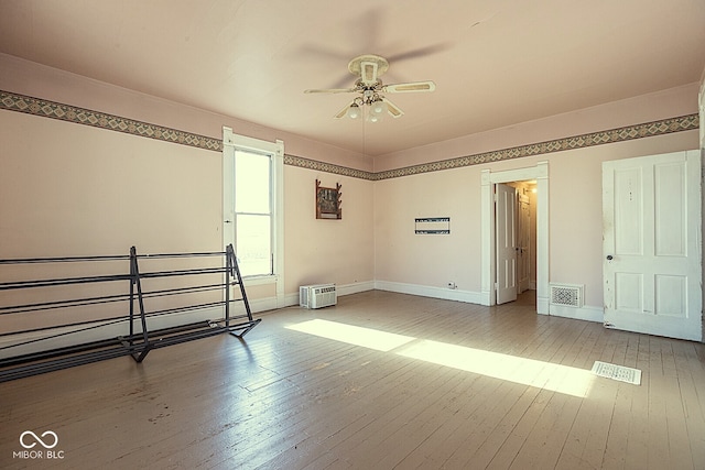 spare room featuring wood-type flooring and ceiling fan