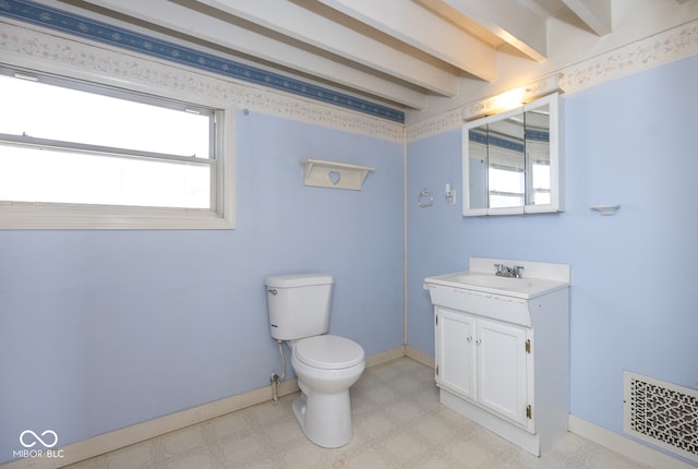 bathroom featuring beamed ceiling, vanity, and toilet