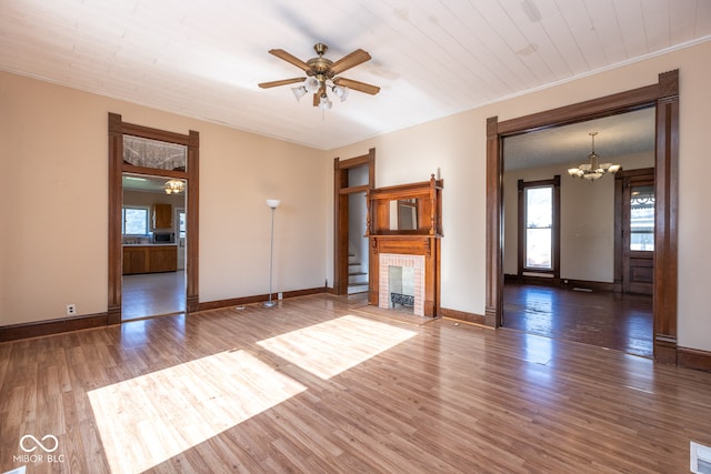 unfurnished living room with ceiling fan with notable chandelier, dark hardwood / wood-style floors, and ornamental molding