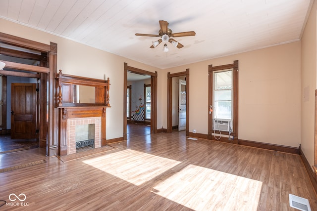 unfurnished living room with hardwood / wood-style flooring, ceiling fan, ornamental molding, and a fireplace