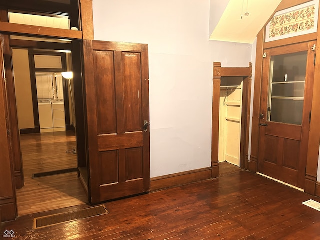 corridor featuring washing machine and dryer and dark hardwood / wood-style flooring