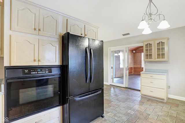 kitchen featuring cream cabinets, pendant lighting, black appliances, and a notable chandelier