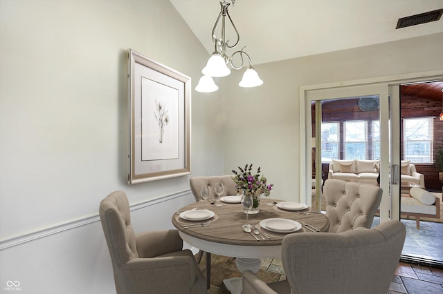 dining area featuring a chandelier and vaulted ceiling