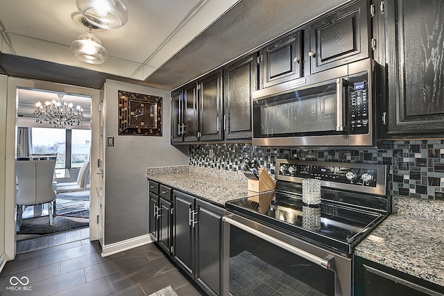 kitchen with backsplash, light stone counters, and stainless steel appliances