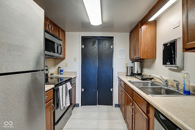 kitchen featuring sink, light tile patterned floors, and stainless steel appliances