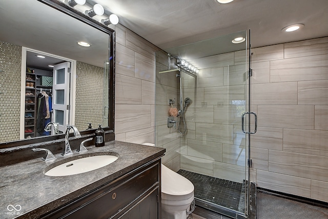 bathroom with vanity, a shower with shower door, and toilet