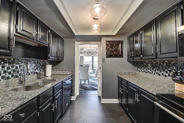 kitchen with light stone countertops, tasteful backsplash, stainless steel appliances, and sink