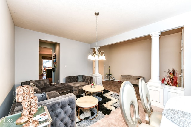 living room with decorative columns, a textured ceiling, and a notable chandelier