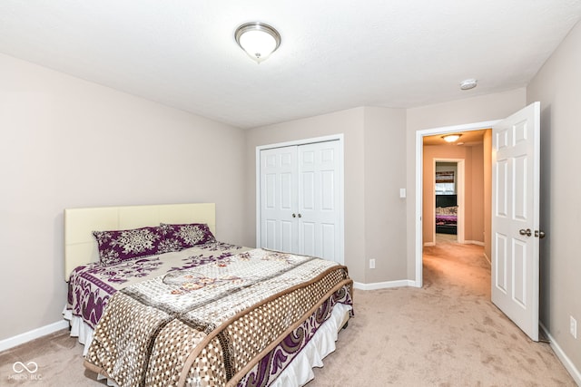 bedroom with a textured ceiling, light carpet, and a closet