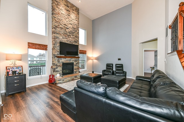 living room featuring a fireplace, dark hardwood / wood-style flooring, and high vaulted ceiling