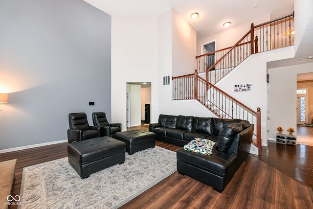 living room with a high ceiling and dark hardwood / wood-style floors