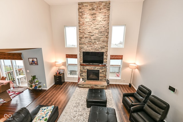 living room featuring a fireplace, a high ceiling, and dark hardwood / wood-style flooring