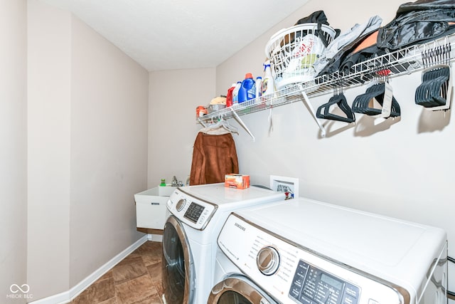 laundry room with a textured ceiling, separate washer and dryer, and sink