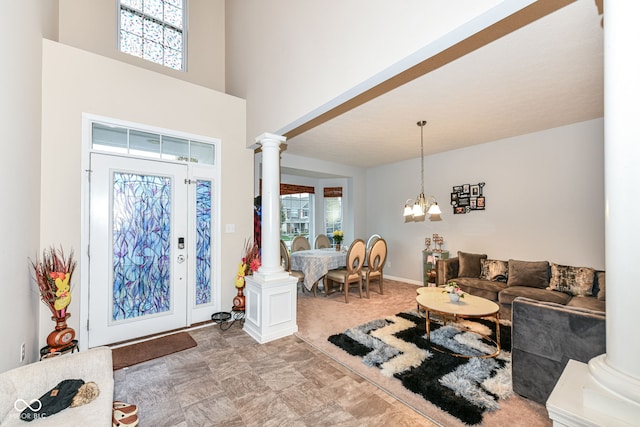 entrance foyer with plenty of natural light, ornate columns, and an inviting chandelier