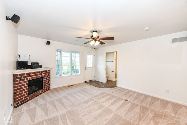 unfurnished living room featuring a brick fireplace, visible vents, baseboards, and light colored carpet