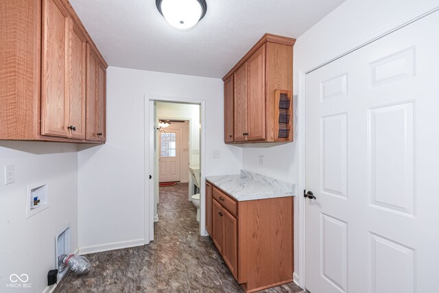 kitchen featuring light countertops, brown cabinetry, and baseboards