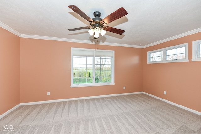 carpeted spare room featuring baseboards, ornamental molding, and a healthy amount of sunlight