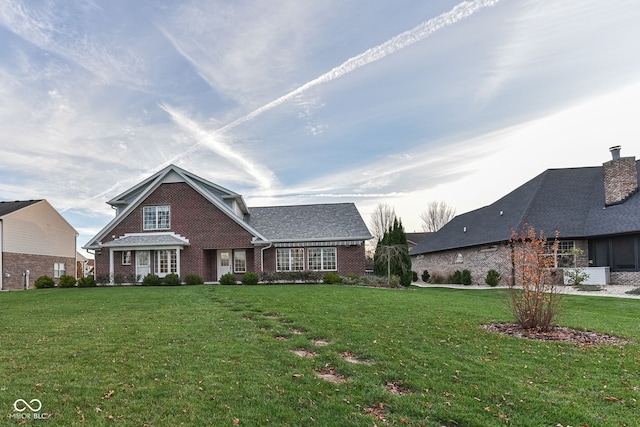 view of front of house featuring brick siding and a front lawn