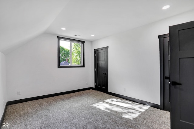 additional living space with carpet floors and vaulted ceiling