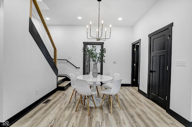 dining room featuring a notable chandelier and light hardwood / wood-style flooring