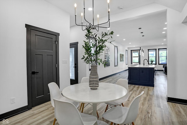 dining space featuring light hardwood / wood-style floors and an inviting chandelier